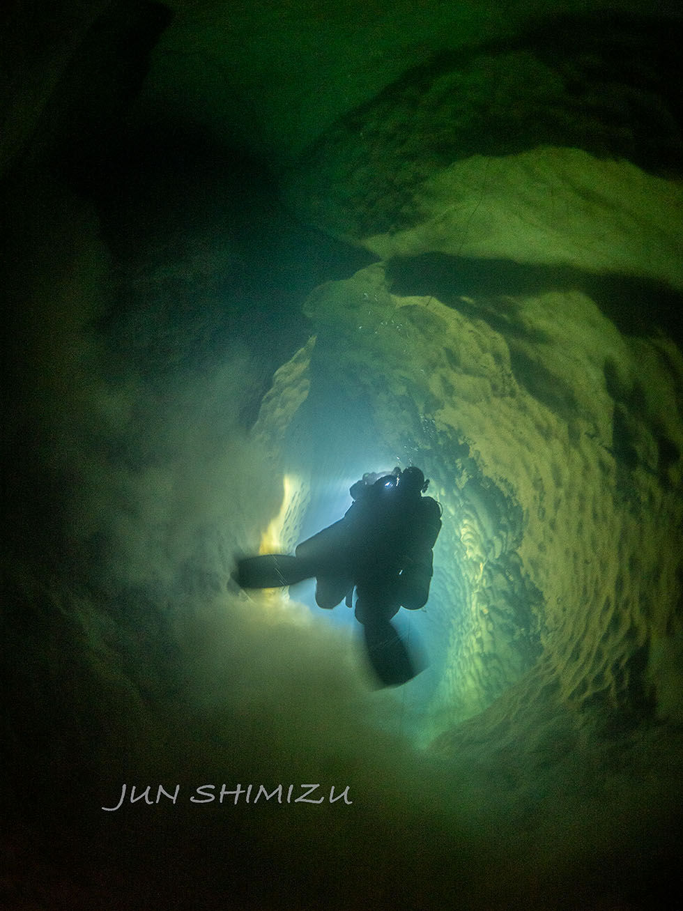 A vertically descending passage. Scalloped patterns can be seen on the sides.