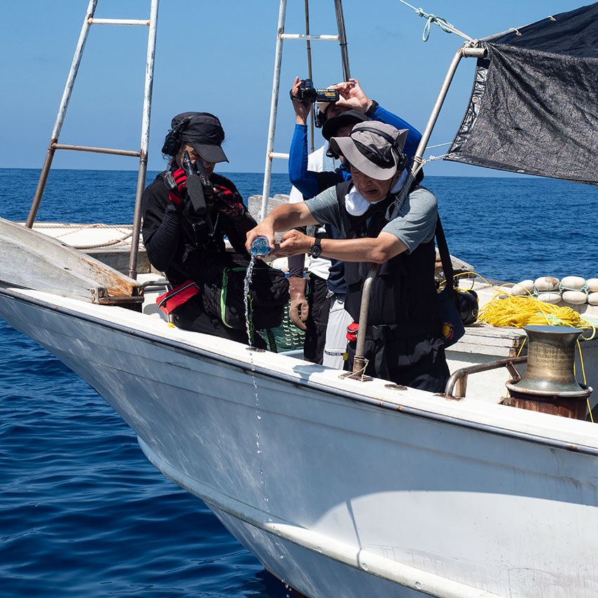 Mr. Nishinaka offers sake from the boat